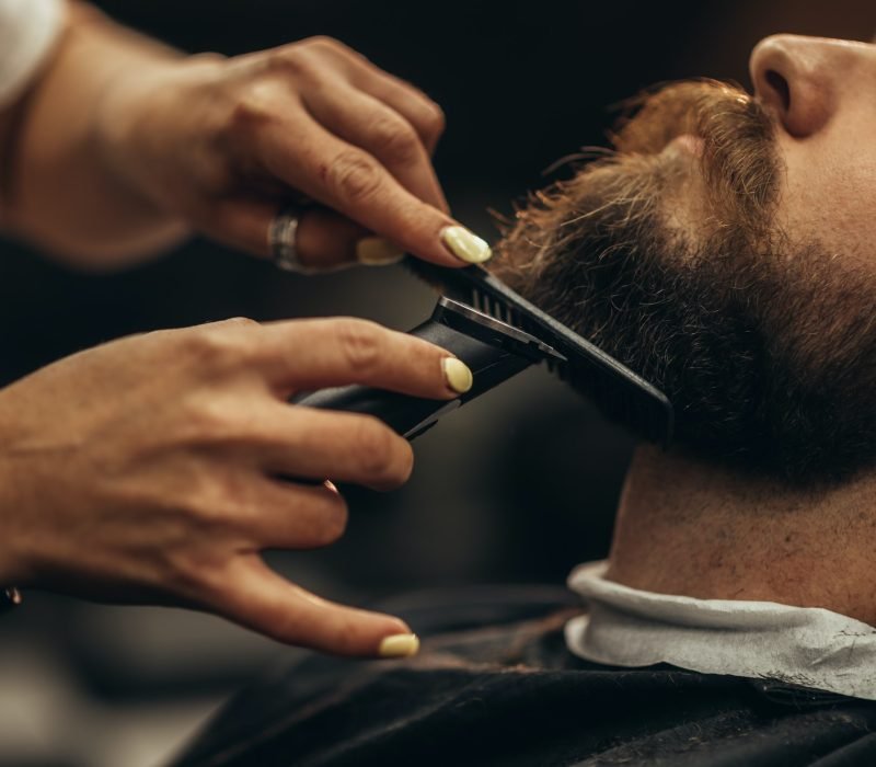 young-bearded-man-getting-beard-haircut-by-hairdresser-2.jpg
